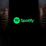Người dùng đang sử dụng ứng dụng Spotify trên điện thoại thông minh với tai nghe kết nối, minh họa sự tiện lợi khi nghe nhạc