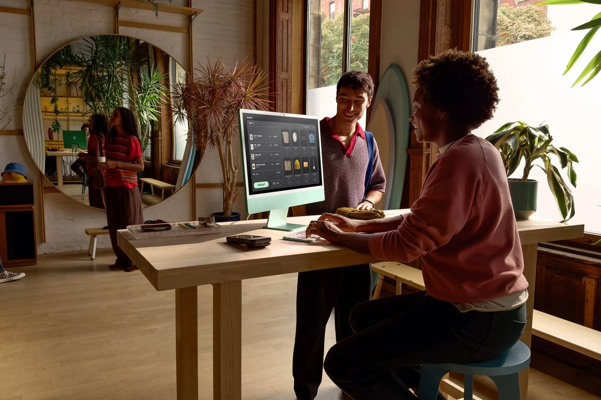 Người dùng làm việc trên iMac đặt cạnh cửa sổ