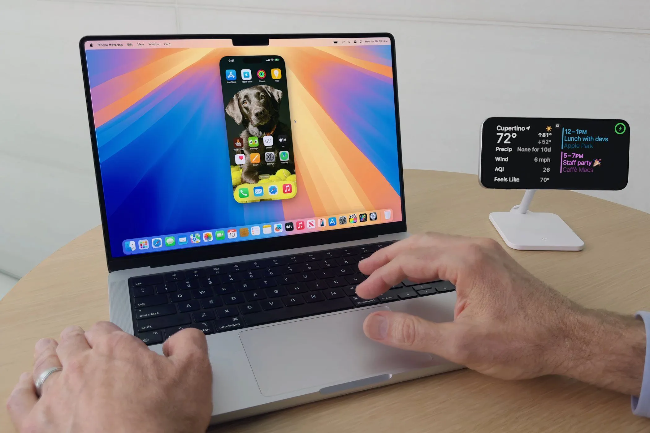 Người dùng thao tác iPhone từ MacBook Pro chạy macOS Sequoia với tính năng Phản chiếu iPhone (iPhone Mirroring)