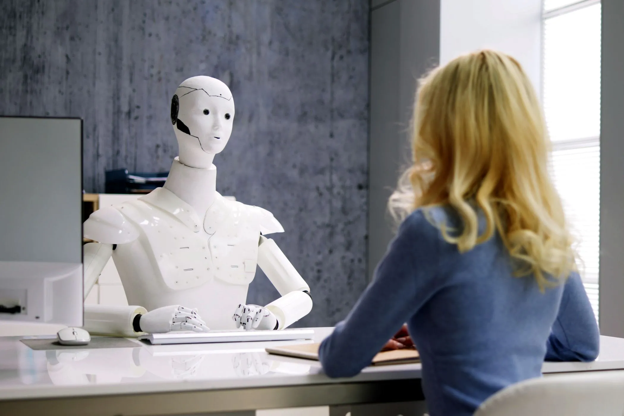 Người phụ nữ phỏng vấn với robot AI, minh họa sự tương tác giữa con người và tác nhân AI