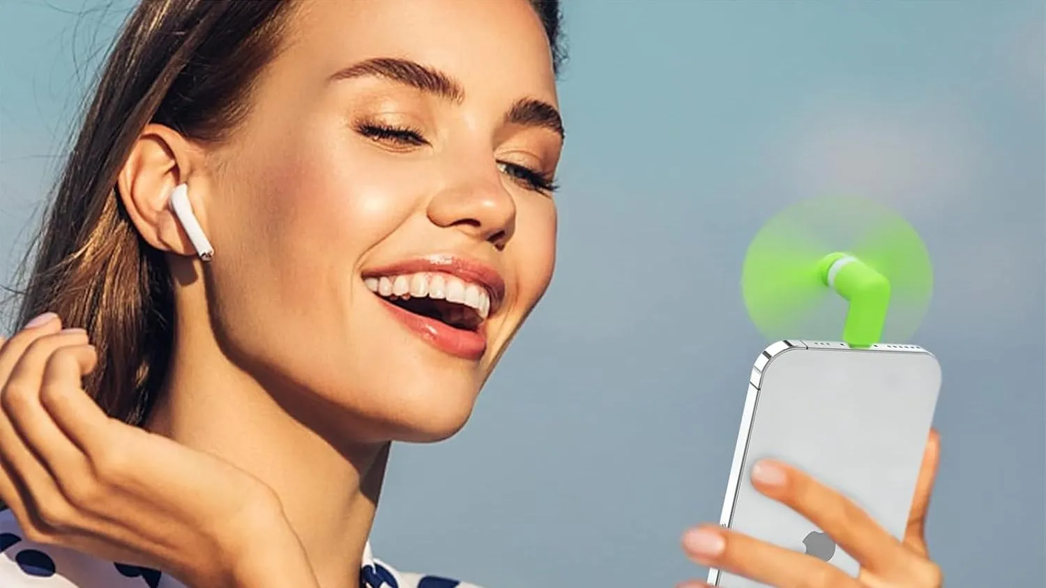 Quạt mini cầm tay cắm vào iPhone, có cánh quạt màu xanh lá cây.