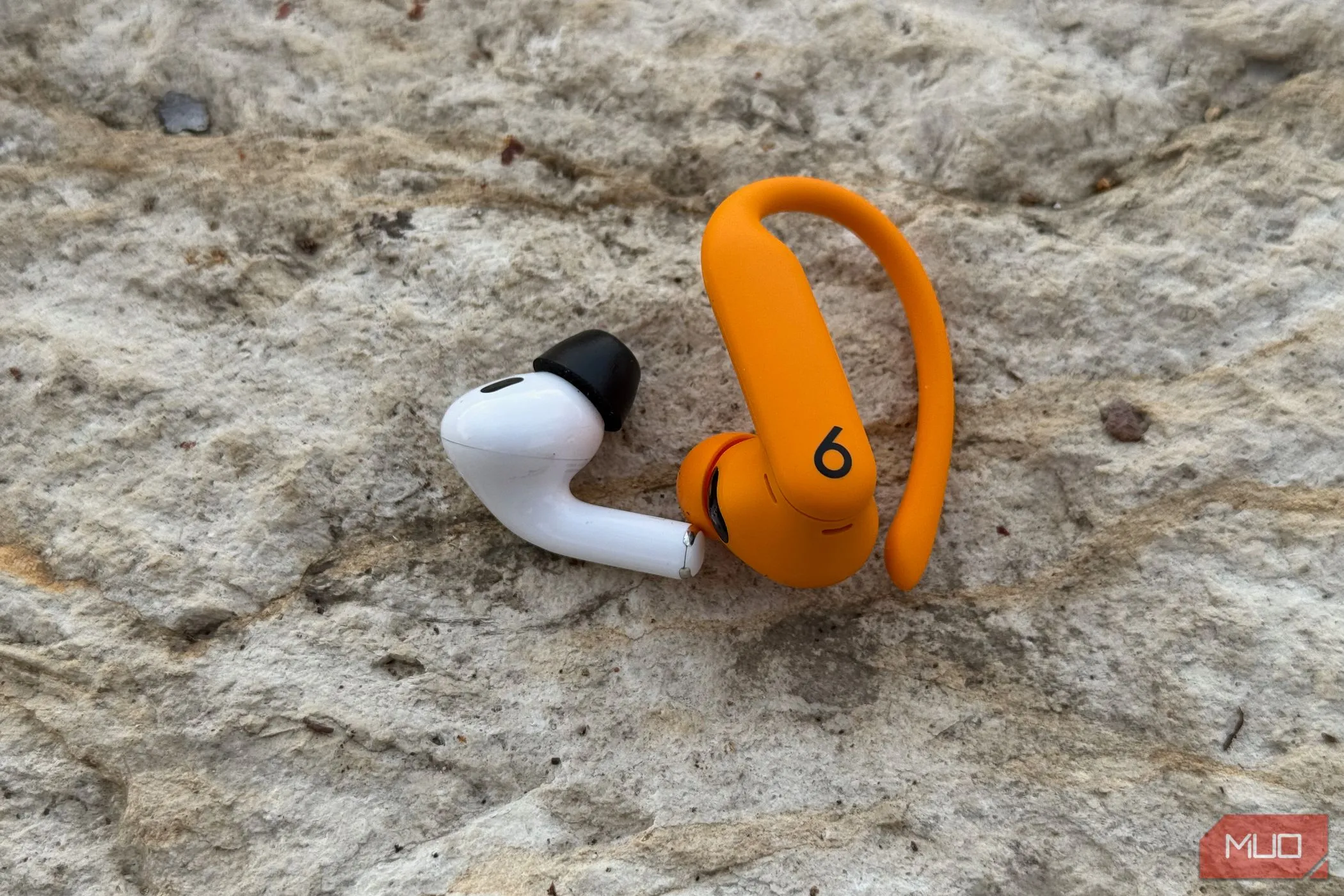 So sánh kích thước và trọng lượng giữa tai nghe AirPods Pro 2 và Powerbeats Pro 2, cho thấy sự khác biệt về thiết kế