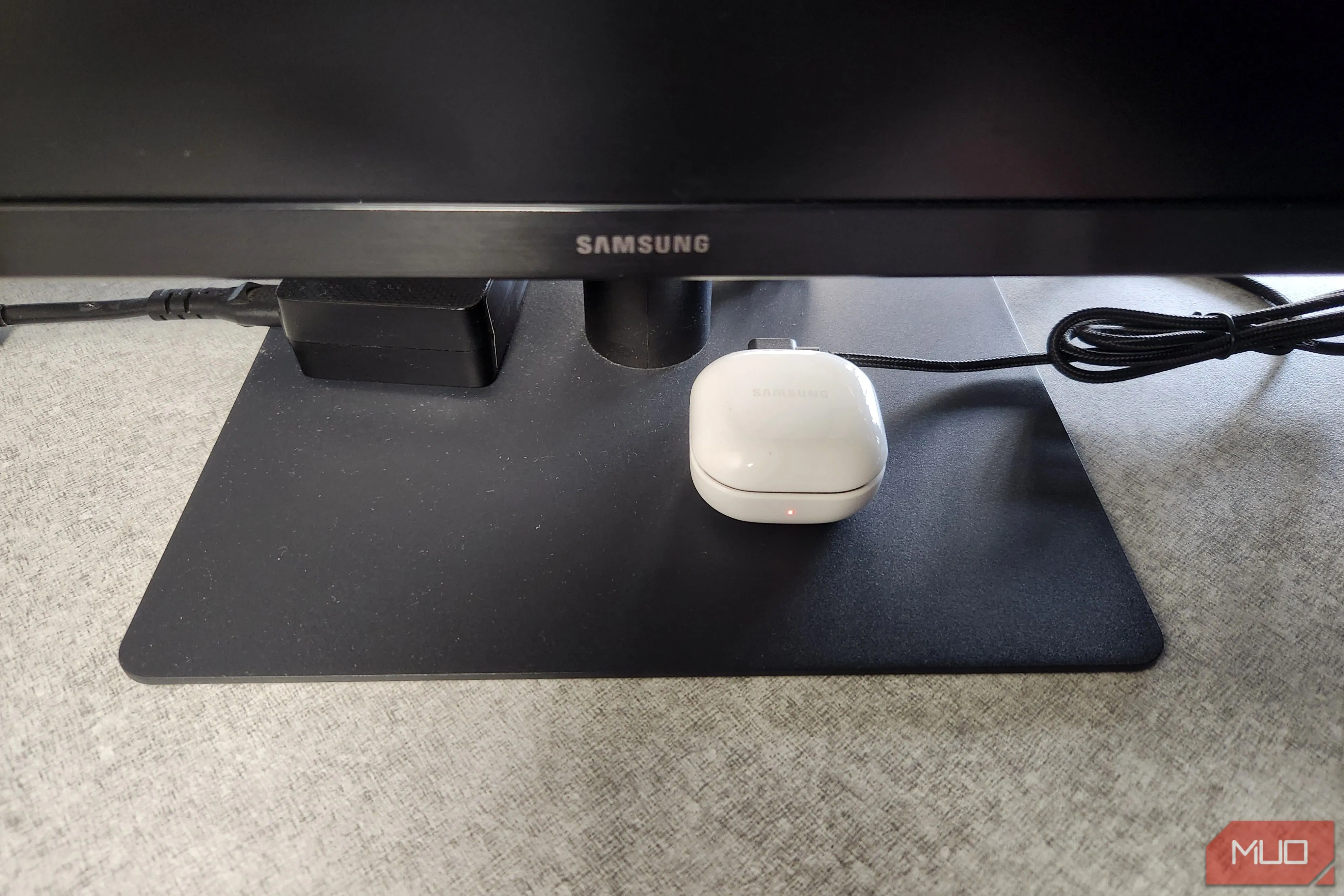 Tai nghe Bluetooth đang sạc qua cổng USB của màn hình máy tính