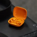 Tai nghe Powerbeats Pro 2 màu cam đang đeo trên tai, minh họa tính năng theo dõi nhịp tim