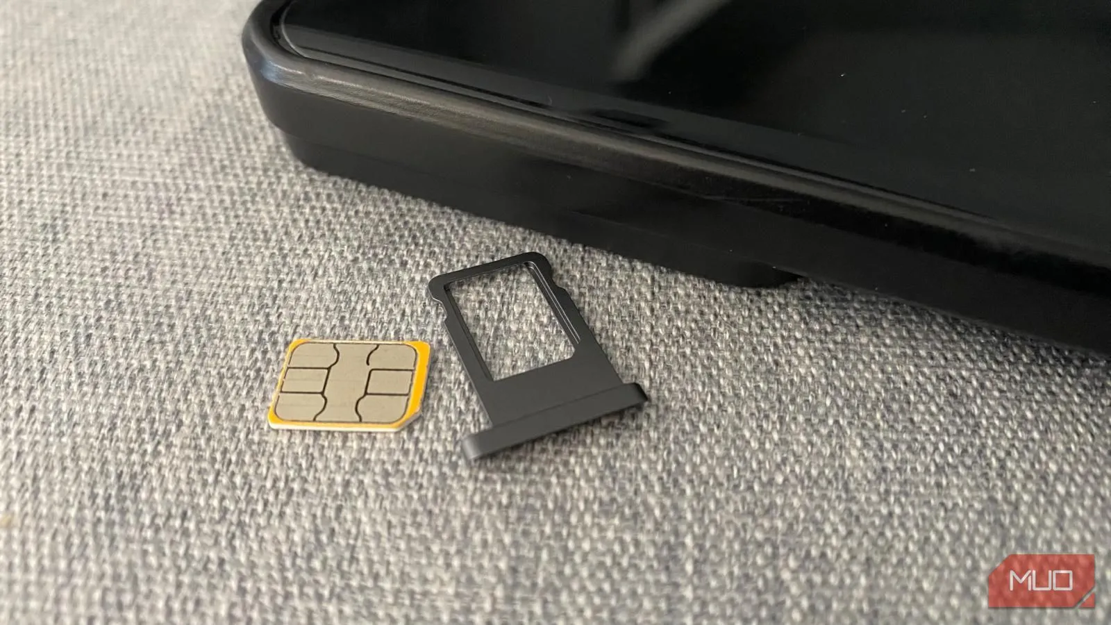 Thẻ SIM vật lý và khay đựng đặt cạnh điện thoại di động trên bàn, tượng trưng cho lựa chọn kết nối truyền thống nhưng ổn định.
