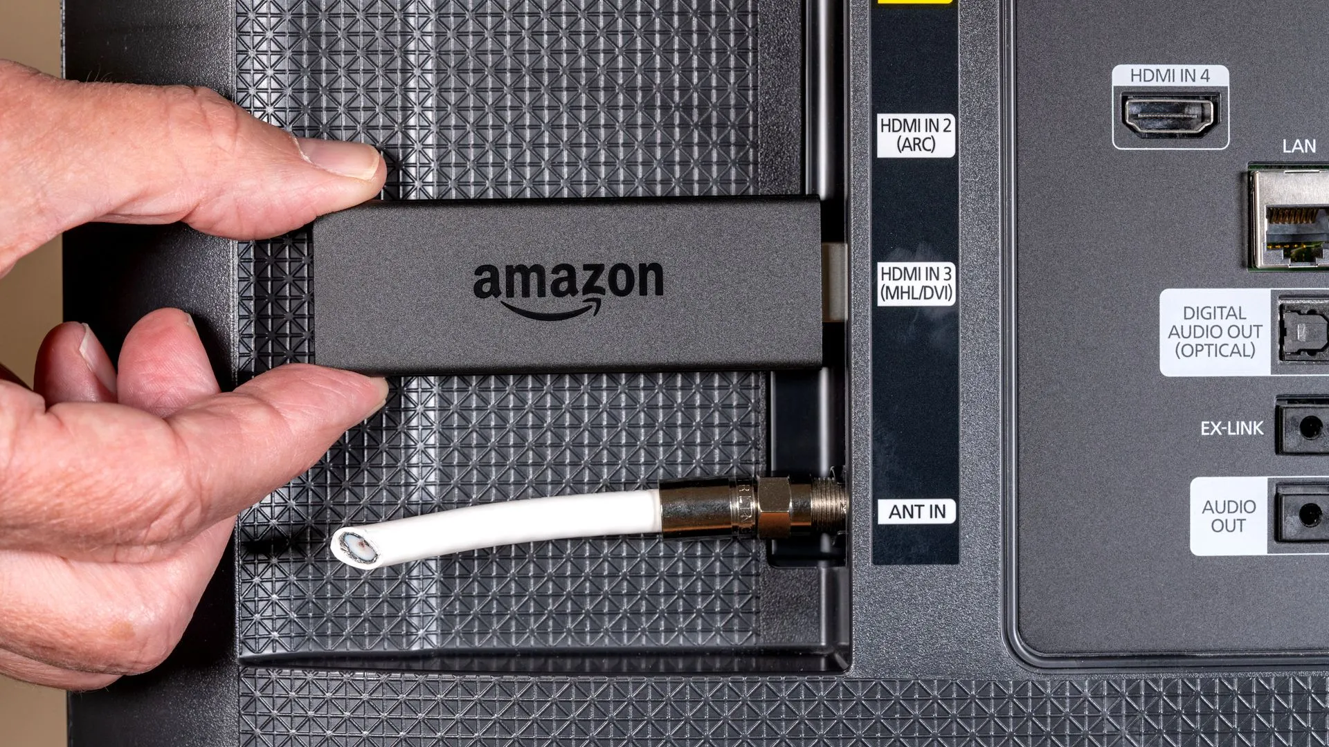 Thiết bị Amazon Fire TV Stick cắm vào cổng HDMI của TV, minh họa việc sử dụng TV thông minh để xem nội dung qua internet thay vì truyền hình cáp truyền thống, đồng thời cảnh báo về việc thu thập dữ liệu