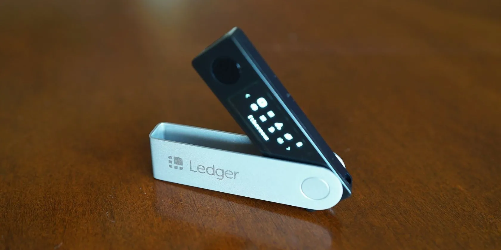 Thiết bị Ledger Nano X đặt trên bề mặt gỗ, thể hiện một ví lạnh crypto.