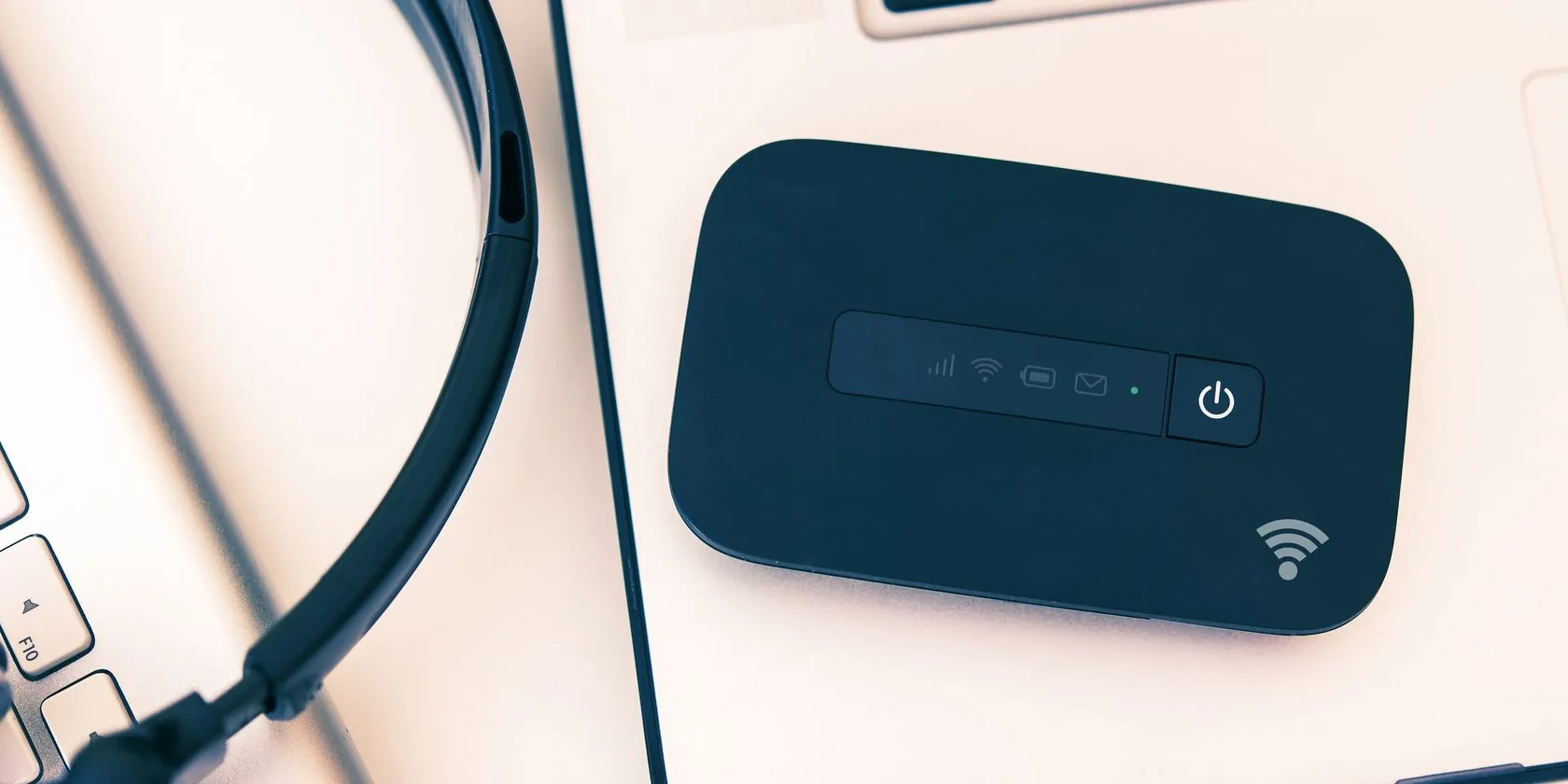 Thiết bị phát Wi-Fi di động (mobile hotspot) đặt cạnh laptop, giải pháp internet ổn định cho dân văn phòng.