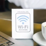 Tín hiệu Wi-Fi và laptop trong phòng khách sạn, minh họa vấn đề kết nối mạng chậm khi du lịch.