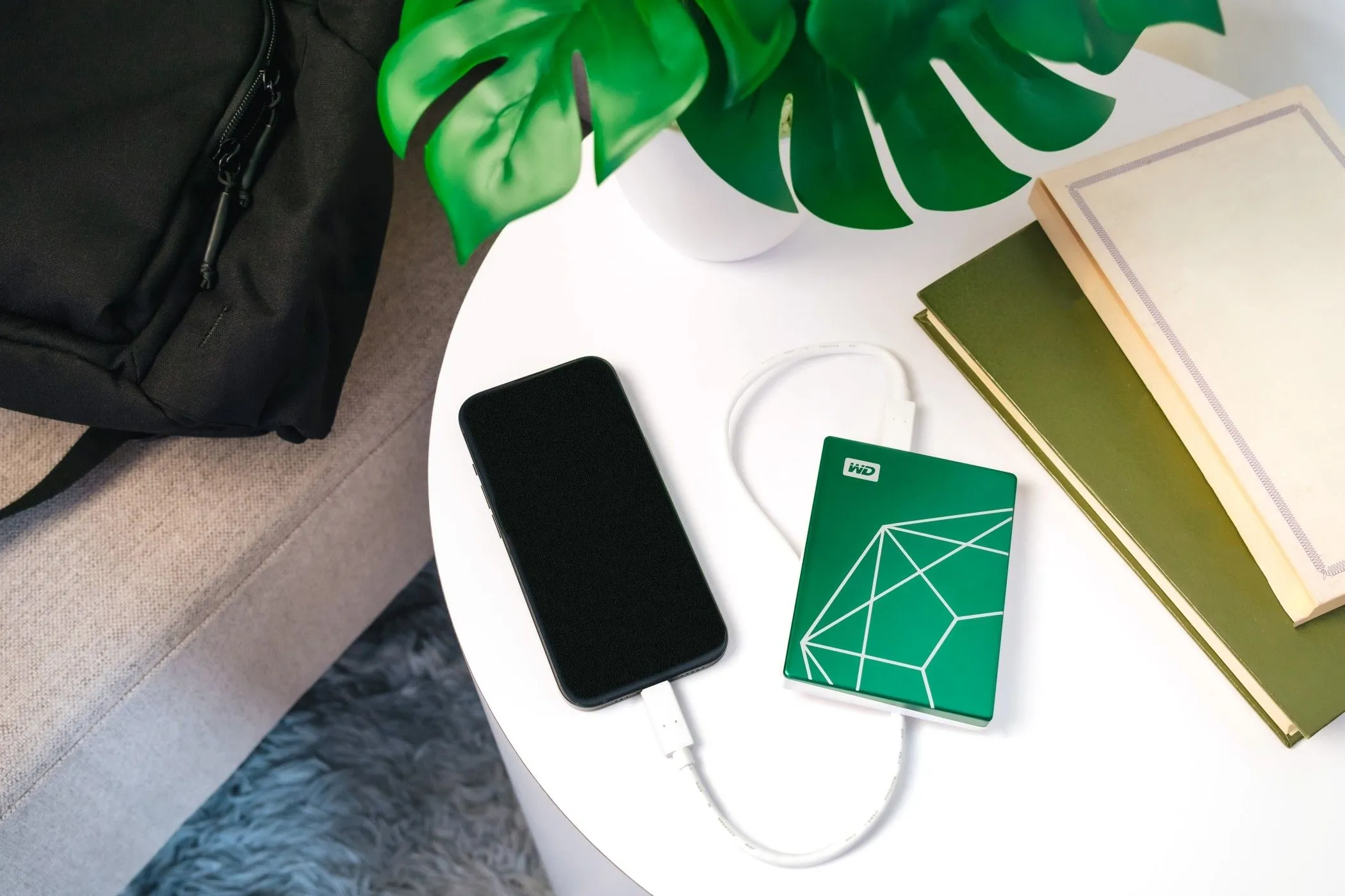 WD My Passport Ultra 20th Anniversary Edition kết nối với điện thoại thông minh trên bàn, minh họa tính di động đa thiết bị